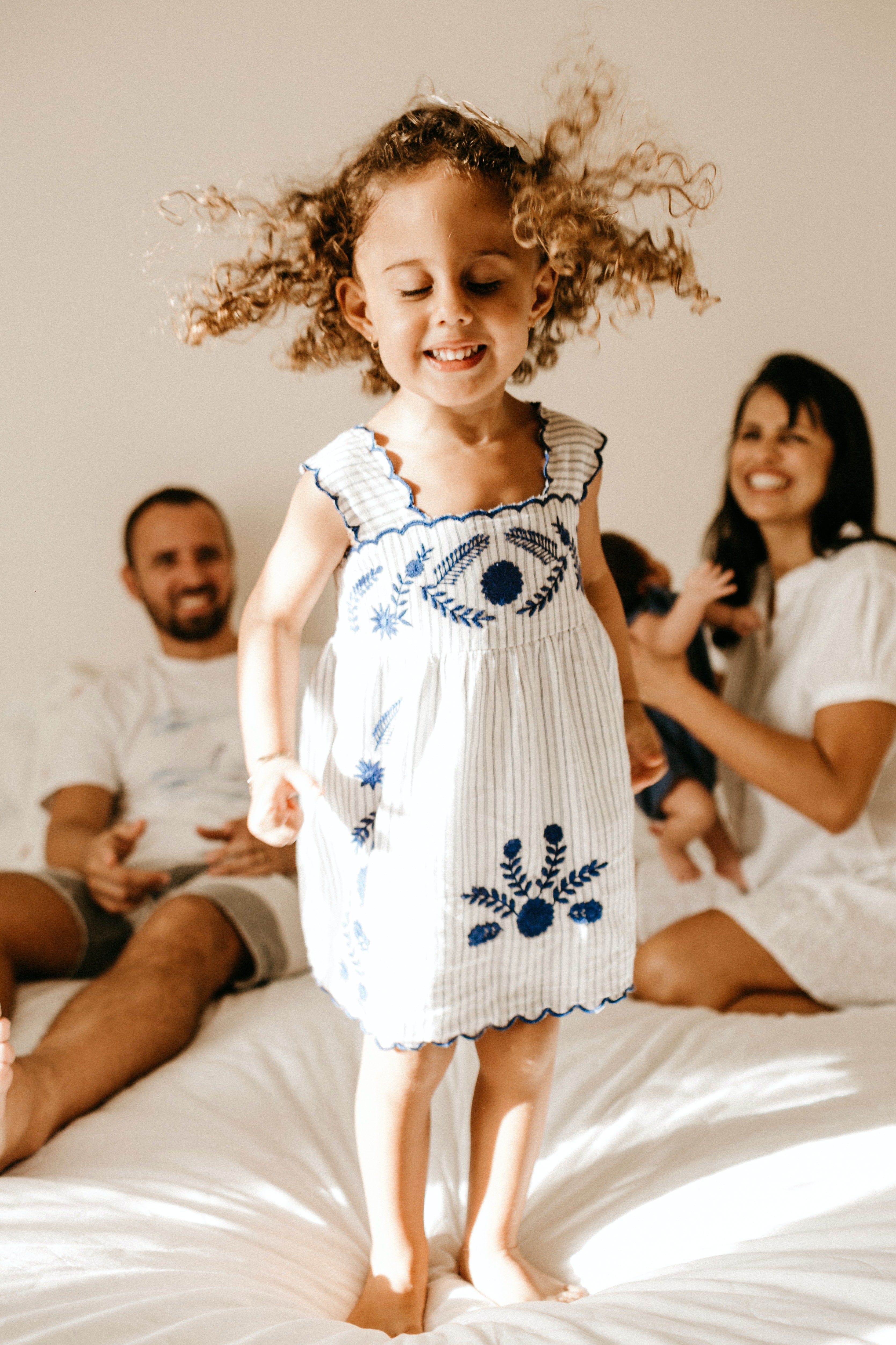 Petite fille aux cheveux bouclés avec ses parents