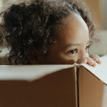 Enfant cheveux bouclés qui se cache