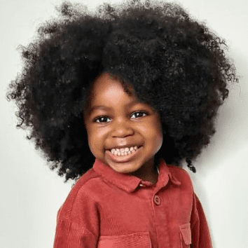 Enfant cheveux crépus qui sourit